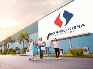 Família sorridente saindo do Shopping China Importados no Paraguai, destacando a variedade de opções para quem deseja comprar roupa de bebê no Paraguai.