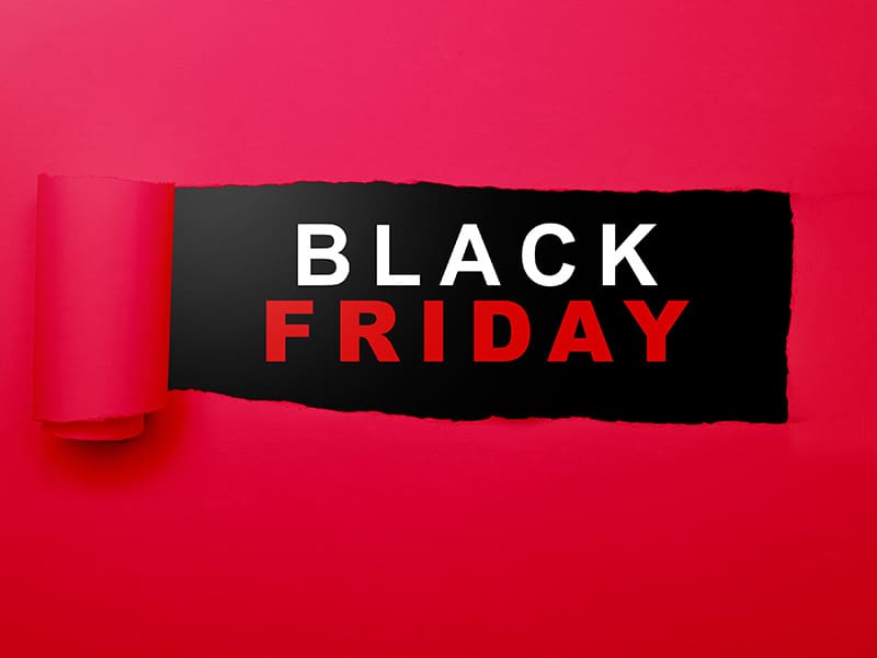 Imagem com fundo vermelho onde uma faixa preta rasgada ao centro revela as palavras 'Black Friday' em branco e vermelho, destacando uma promoção especial.